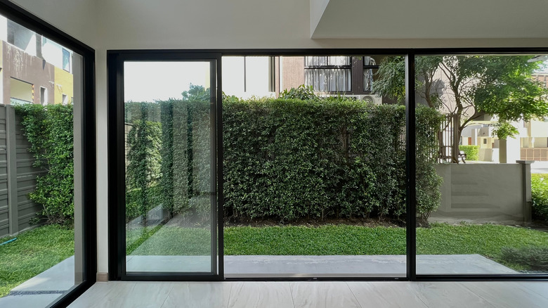 Double sliding door with green garden of backyard view.