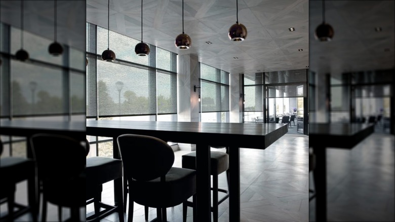 Dark roller shades over sliding glass doors in modern all black and grey interior.