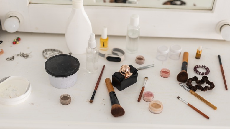 messy white countertop of beauty items