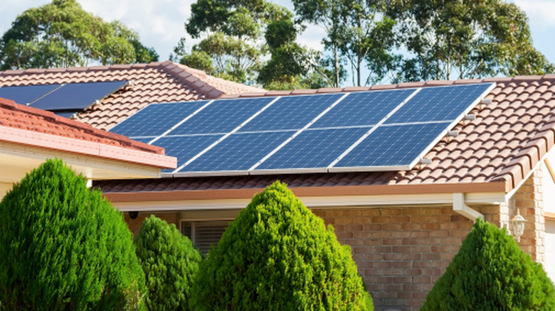 A home with a red tile roof with solar panels installed