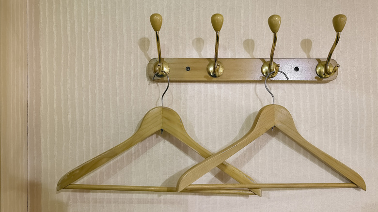 Two wooden clothes hangers hanging from a rack