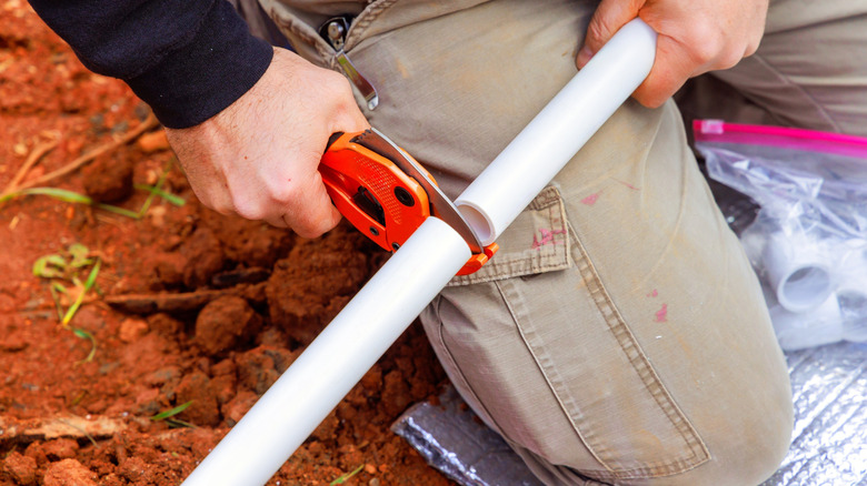 Hand cutting a PVC pipe