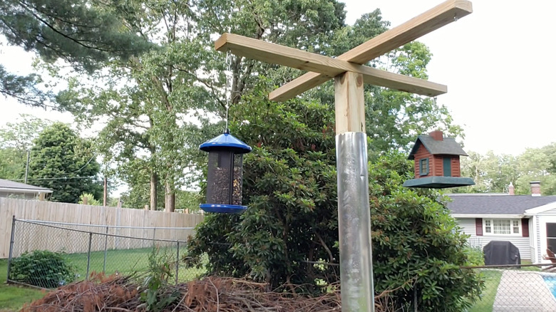 A wooden bird feeder frame with the upright section wrapped in sheet metal