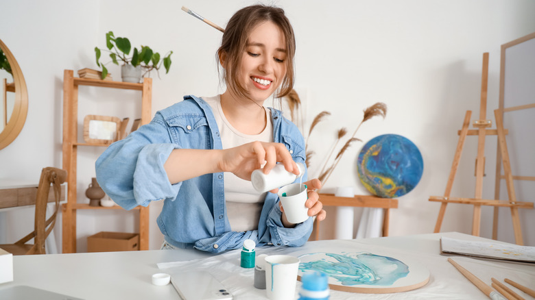 A young woman sits at a table doing craft projects