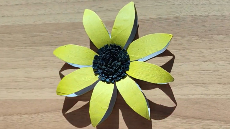 Making a DIY sunflower decoration out of empty toilet paper rolls