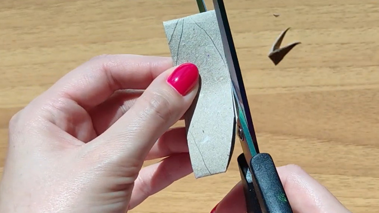 Cutting a ring of toilet paper tube into a petal to make a sunflower