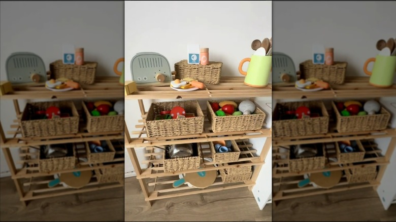Play kitchen with shoe rack holding baskets containing pans and play food