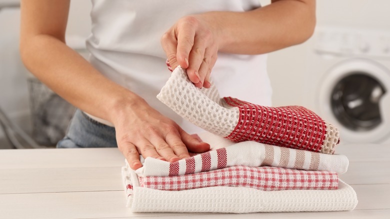 woman folding cleaning towels