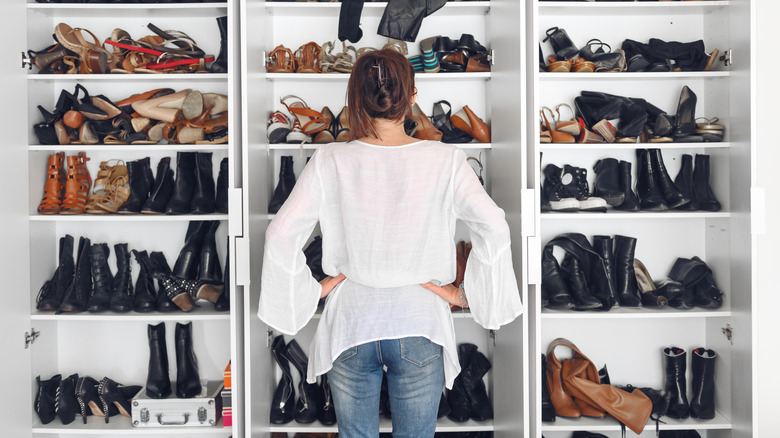 woman faces wall of shoes