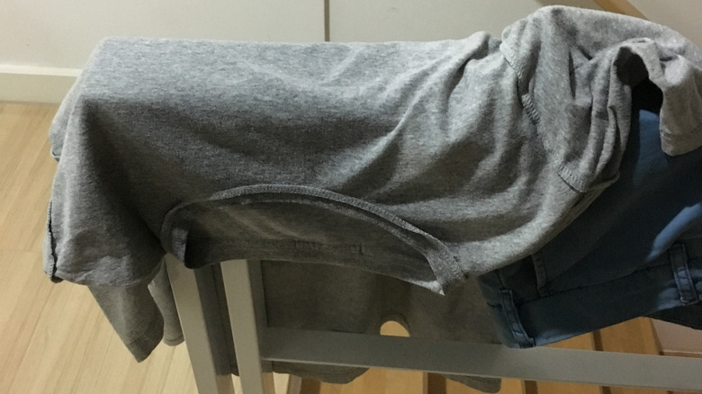 Sweaty t-shirt hanging over a staircase's banister