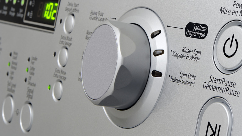 Silver knob and controls of a washing machine