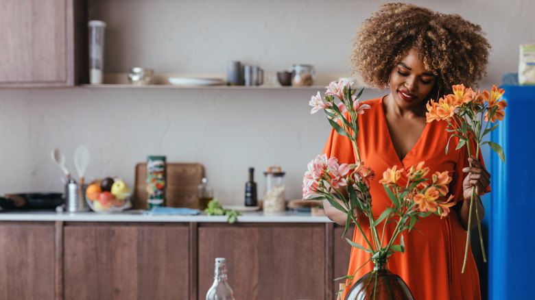 Woman putting flowers in vase