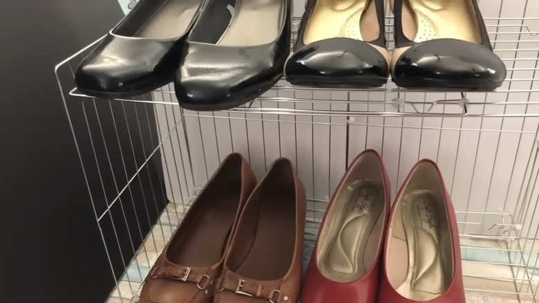 Four pairs of shoes on a metal shoe rack made out of cooling racks