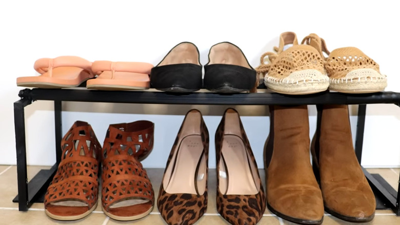 A black shelf with six pairs of women's shoes