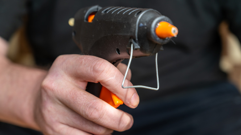 Person holding glue gun