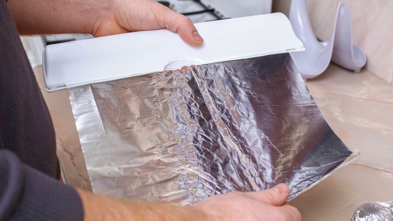 Person pulling sheet of foil