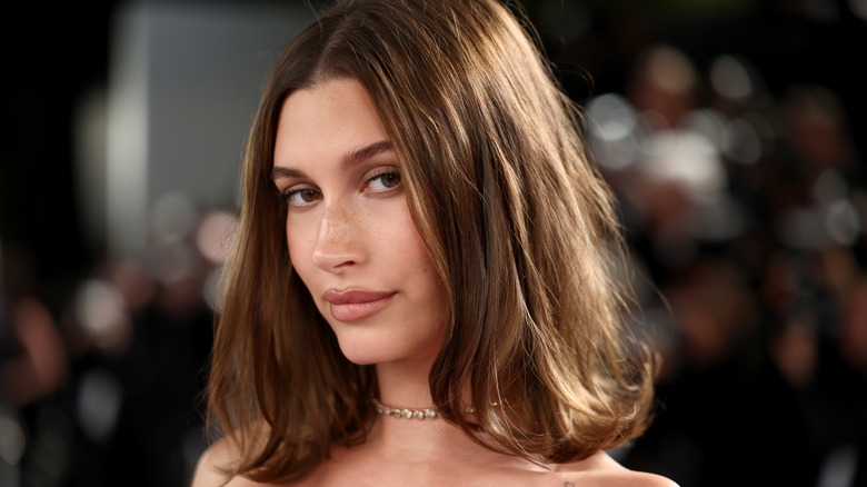 Hailey Bieber smiling for a photo at an event