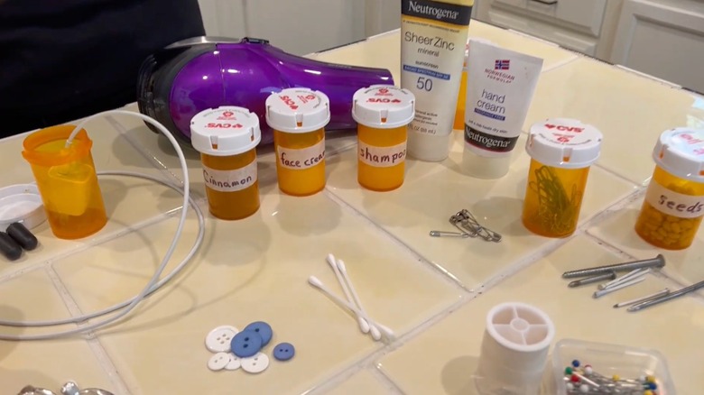 Bathroom tile with various items and labeled pill bottles spread about