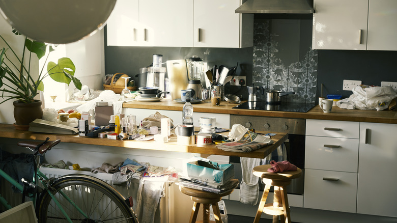 Messy and cluttered kitchen with bicycle leaning on the counter