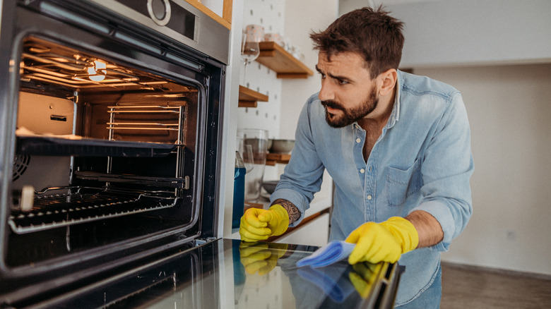man cleaning oven