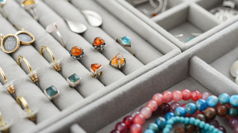 Jewelry is neatly organized in gray velvet jewelry storage