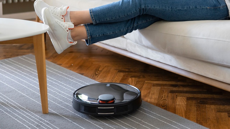 robot vacuum beneath propped feet
