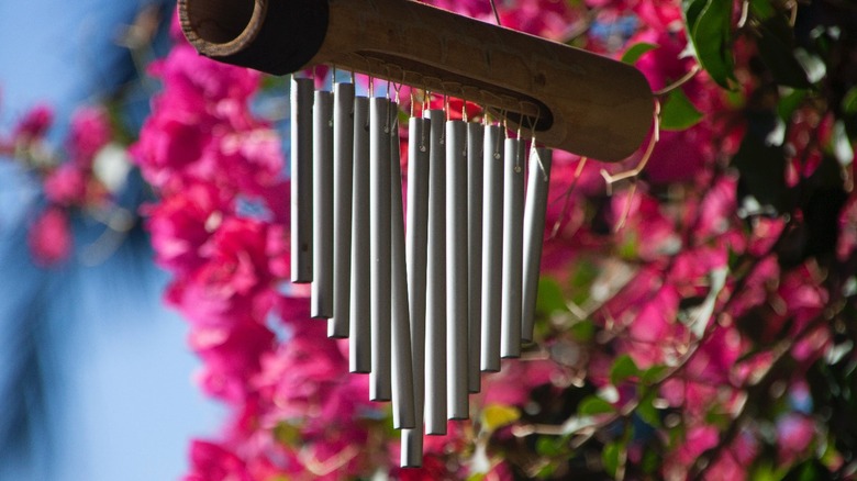Wind chime hanging by pink flowers