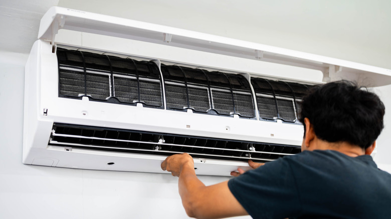 Professional technician working on mounted HVAC unit