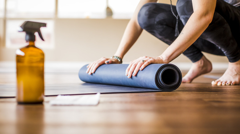 person rolling up yoga mat