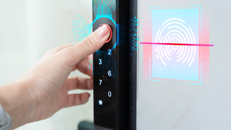Hand using fingerprint scanner on door lock