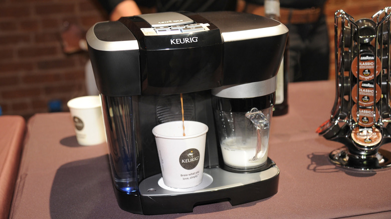 A black Keurig coffee maker brewing coffee