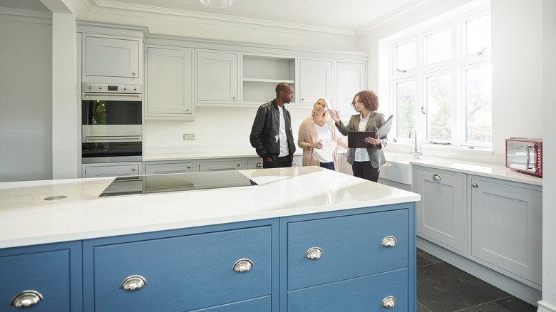 Couple discussing kitchen cabinet with realtor