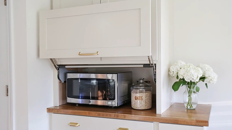 A kitchen appliance garage in a white cabinet and laminate wood countertop kitchen.