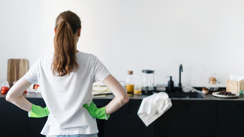 A women getting ready to organize cluttered kitchen counter.