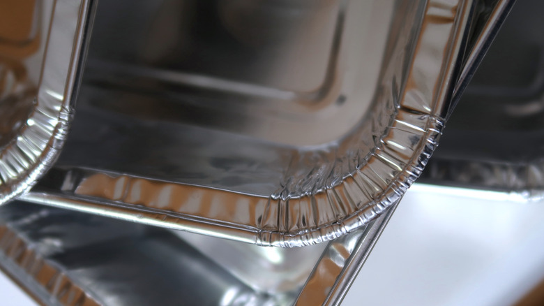 Several foil pans stacked on top of eachother on a counter