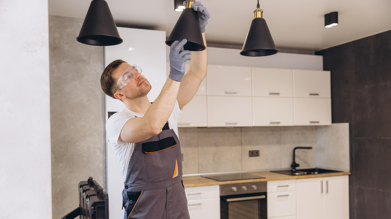 electrician installing modern pendant lights