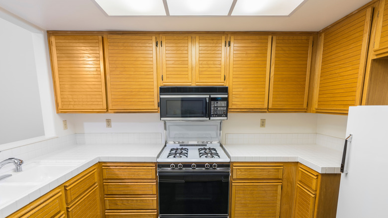 An outdated kitchen with fluorescent box lighting