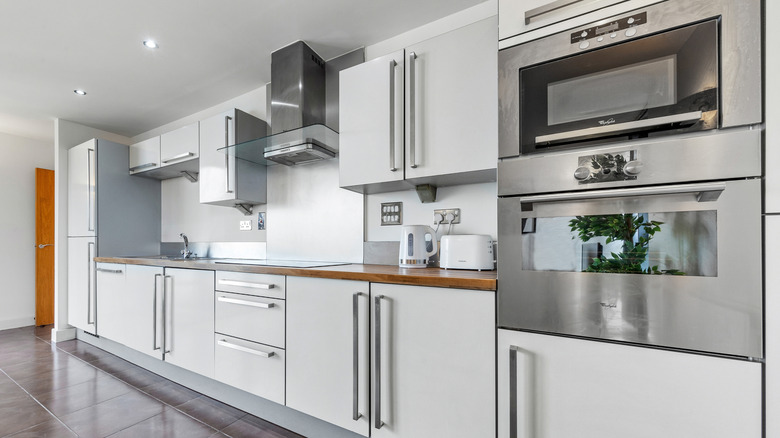 a modern kitchen containing appliances and cabinet hardware with stainless steel finishes