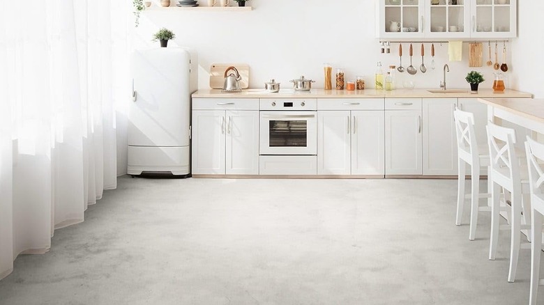 A bright white kitchen with light cement floors.