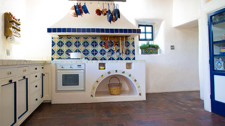 A Spanish style kitchen with brick floors.