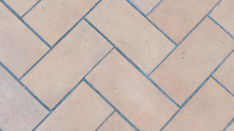 A close up on beige herringbone tiles.