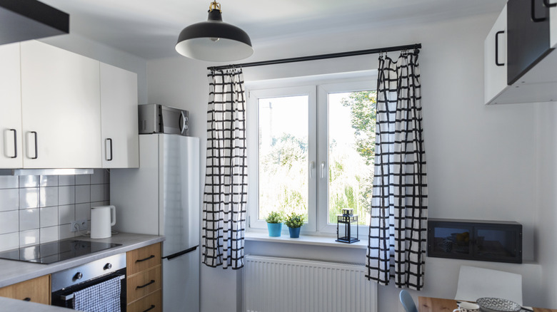 An updated kitchen with black and white checkered curtains