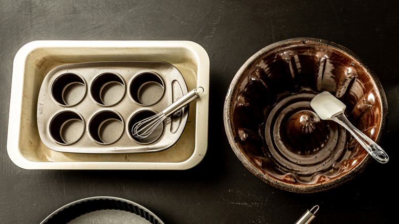 A red bird eating seed out of a glass bird feeder