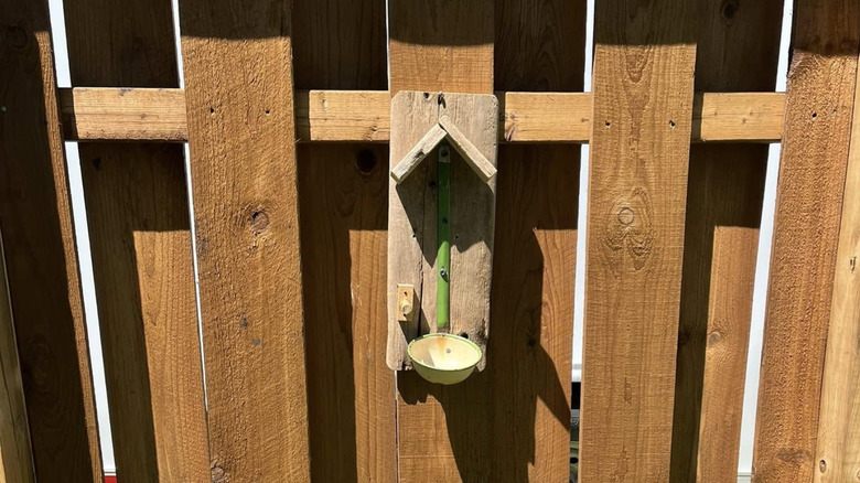 A bird feeder made with a soup ladle and wood