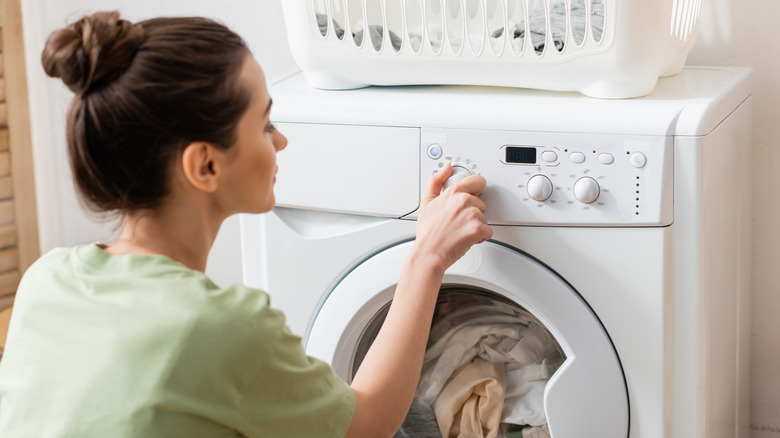 a woman chooses settings on a dryer