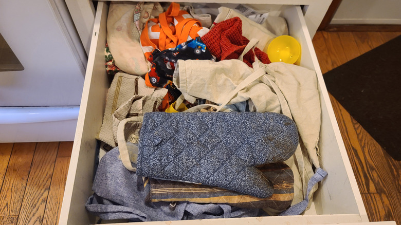 a messy drawer of kitchen linens