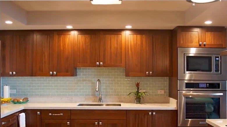Lights on a kitchen soffit make it seem purposeful and help brighten the warm cabinetry
