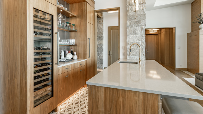 Kitchen with wet bar, wine cooler, and wood cabinetry with glassware