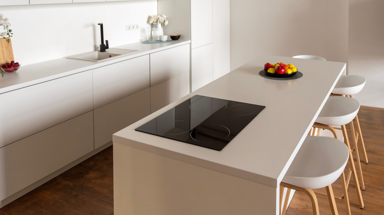White kitchen interior with induction hob and island