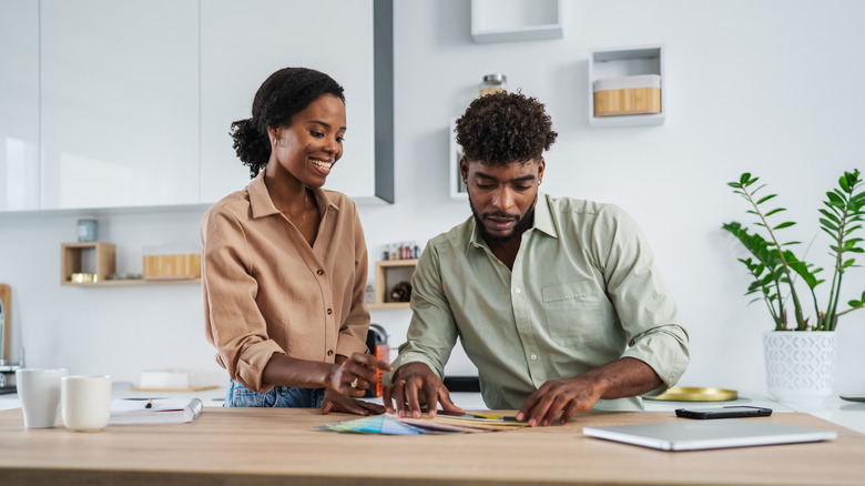 A couple discussing color options for a kitchen remodel